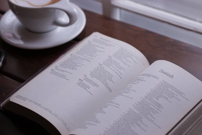 打开圣经，在咖啡杯旁的桌子上展示以赛亚的章节